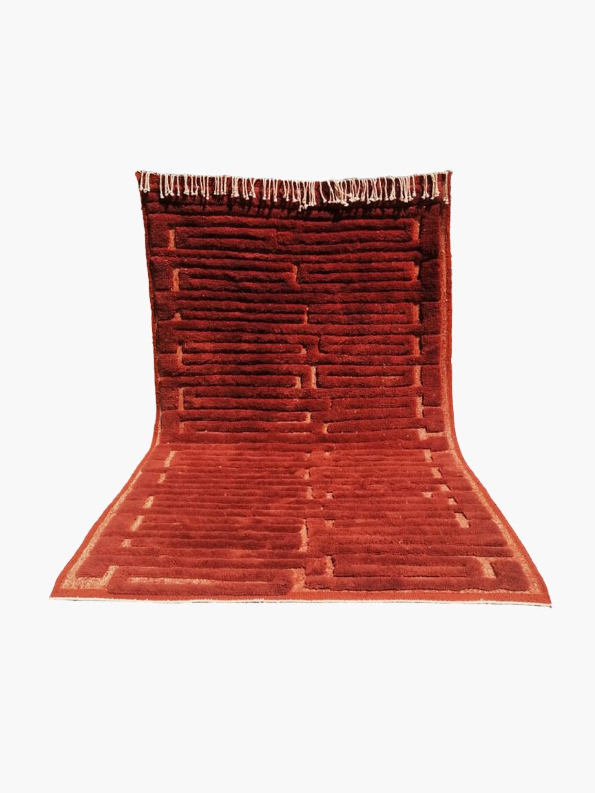 A rectangular, flatweave, red wool rug with a fringed edge.